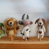 Set of plush animal toys on a wooden stand against a white wall.