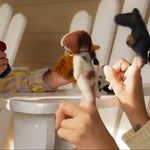 Child playing with stuffed animals on a white chair