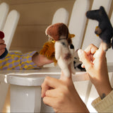 Child playing with stuffed animals on a white chair