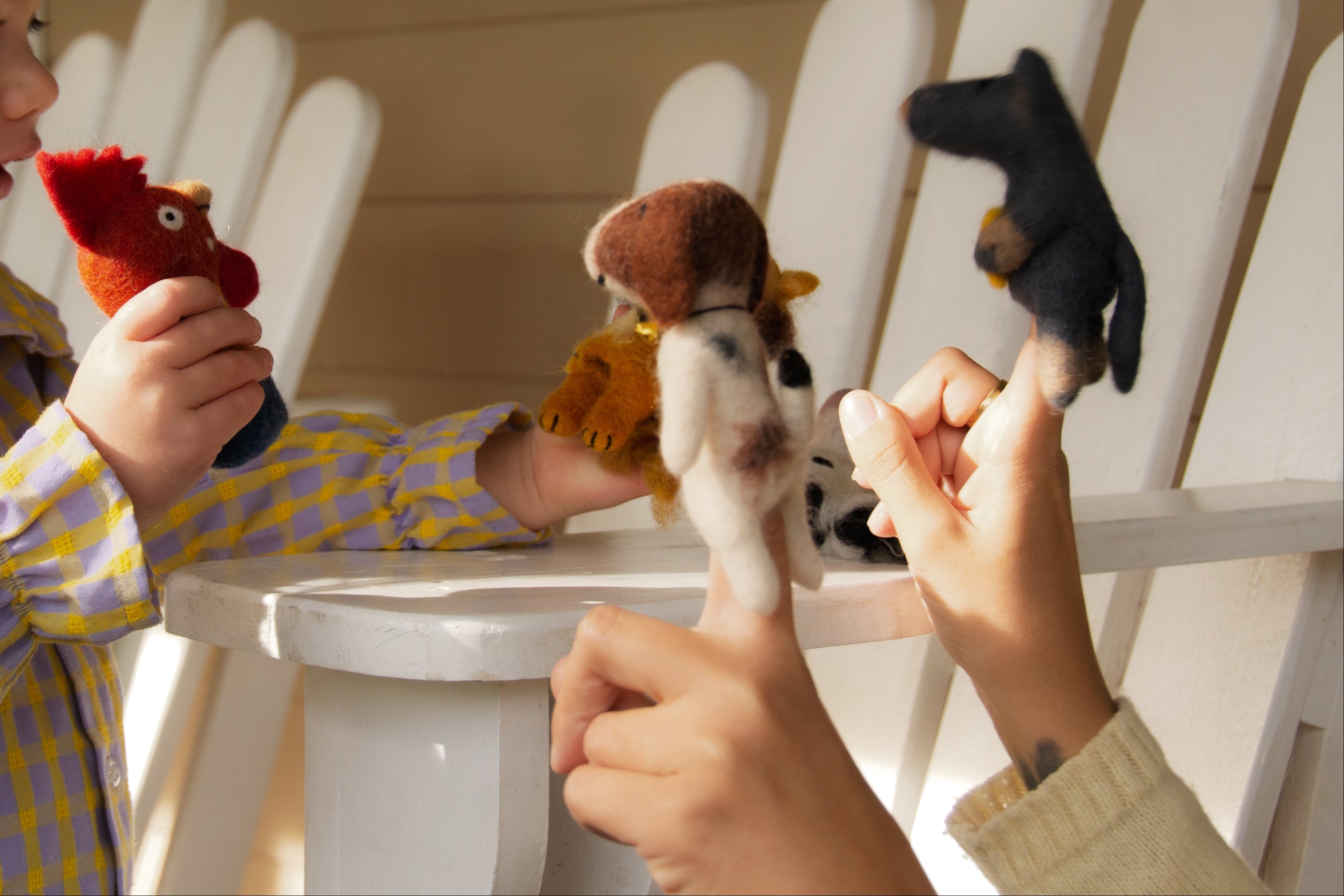 Child playing with stuffed animals on a white chair