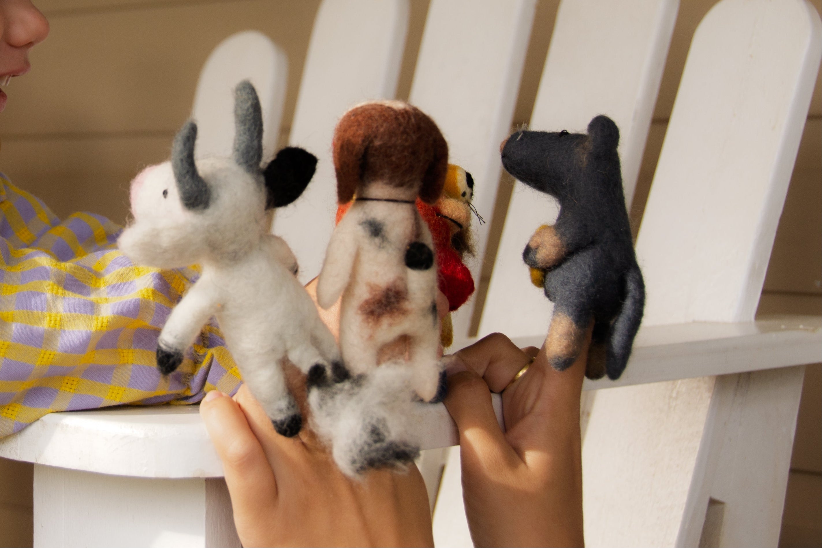 Child playing with stuffed animals on a white chair
